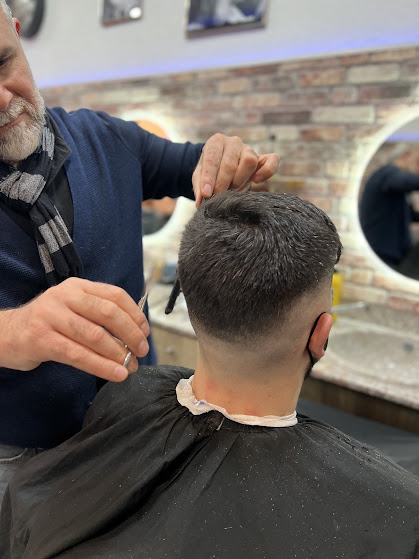 Friseurmeister beim Haareschneiden mit Schere